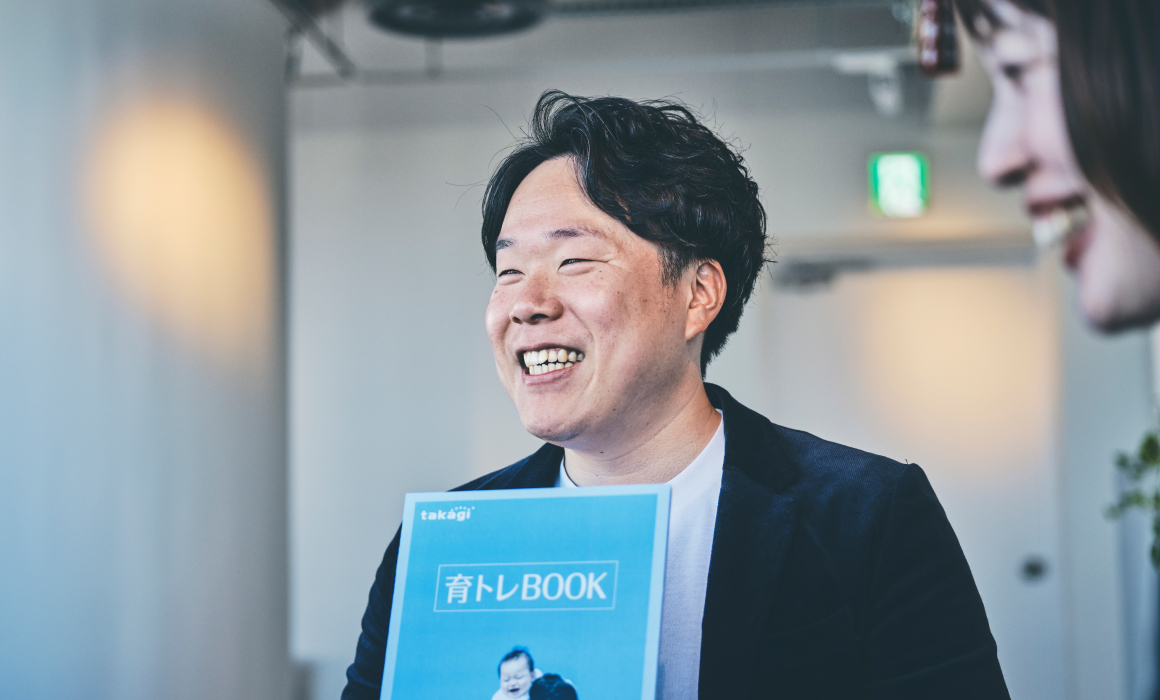 育トレBOOKを手にする社員 写真